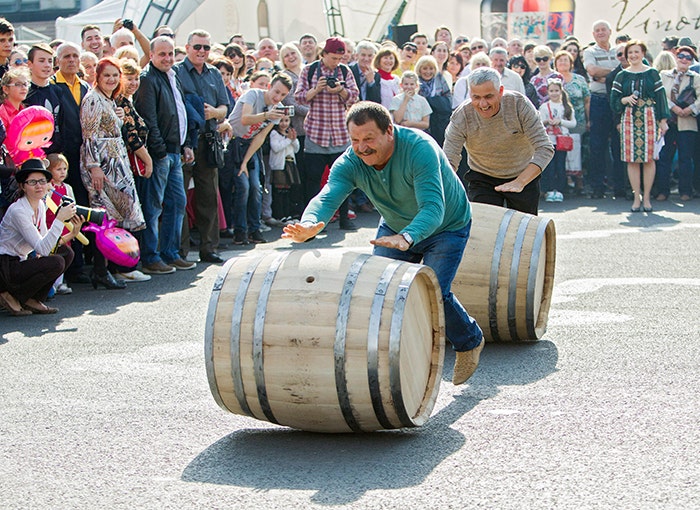 Two men in a wine barrel rolling competition during the celebration of National Wine Day in The Great National Assembly Square, Chisinau, Moldova / EPA, Alamy