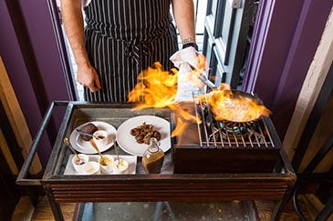 Food being cooked over an open flame at One Fifth