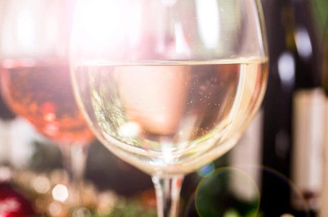 Close up of white wine in glass, backlit