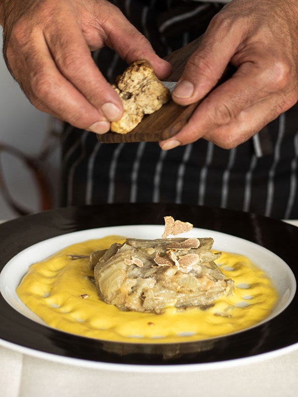 Chef shaving Alba white truffles on dish