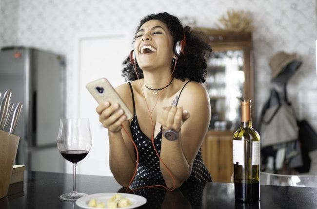 Woman Listening to a wine podcast at Home