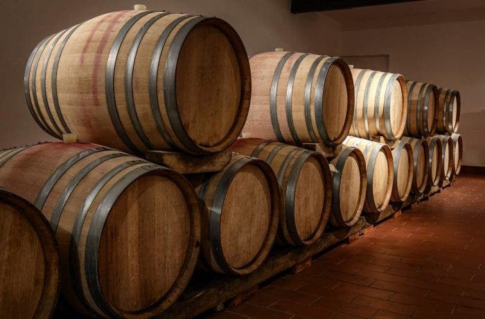 Rows of oak barrels in wine cellar_GettyImages-652046364