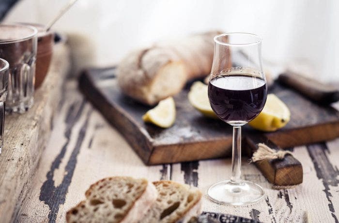 Glass of fortified and bread on wood cutting board-668769835_1920x1280