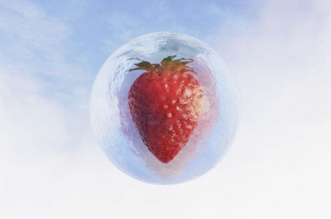 round ice cube with a strawberry in it